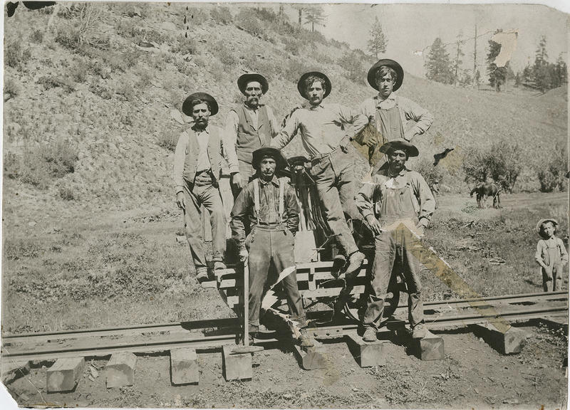 Mexican box car rail workers standing on unbuilt tracks